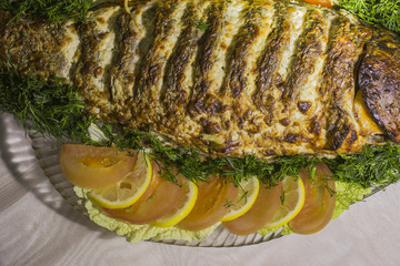 Stuffed carp, decorated with vegetables. Fish dish.