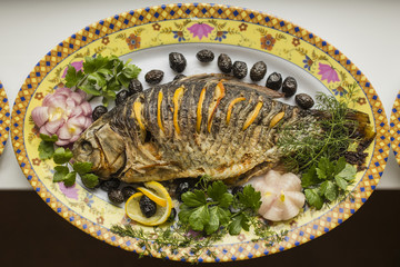 Stuffed carp, decorated with vegetables. Fish dish.
