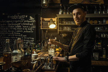 Bartender working behind the bar. Prepares a cocktail.