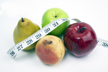 Tape measure wrapped around fresh fruit and isolated on a white background.