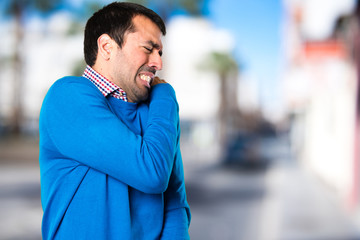 Fototapeta premium Handsome young man with shoulder pain on unfocused background