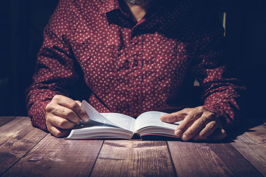 Pastor studying the Bible on a wooden desk
