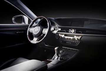 Luxury car inside. Interior of prestige modern car. Comfortable leather seats. Black perforated leather cockpit with isolated black background, clipping path included