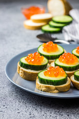 Red caviar bites with cucumber. Selective focus, space for text. 