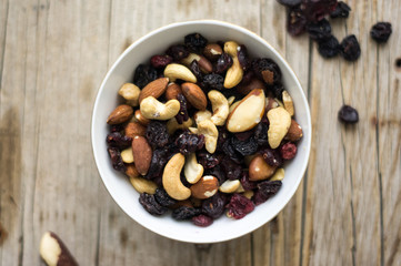 Bowl of mixed nuts and dried fruits on the wooden table