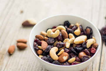 Bowl of mixed nuts and dried fruits on the wooden table
