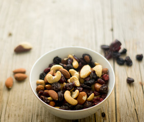 Bowl of mixed nuts and dried fruits on the wooden table