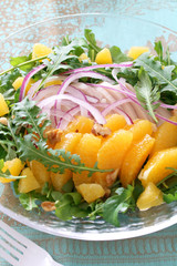 Summer salad with arugula, boiled chicken breast, red onion, and orange 