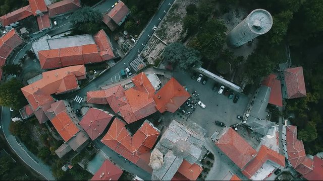 Overhead rotating drone shot of orange clay rooftop houses in Roccaverano, Italy