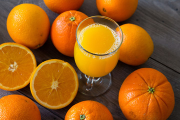 Natural orange juice in a glass on top of a wooden table