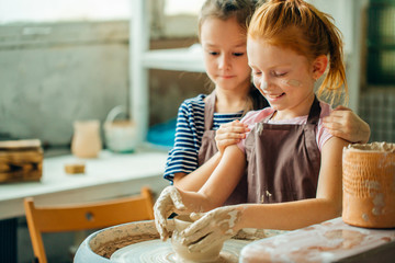 Ceramic working process with clay potter wheel. Two girls making pottery in studio