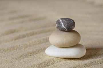 Fototapeta na wymiar Pile of balanced stones on sand