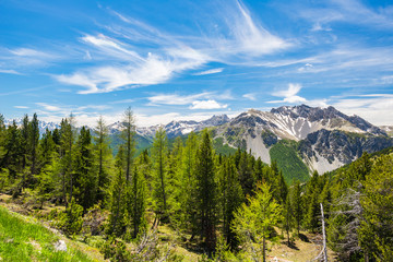 High altitude blue lake in idyllic uncontaminated environment once covered by glaciers. Summer adventures and exploration on the Italian French Alps. Expansive view from above, clear blue sky.