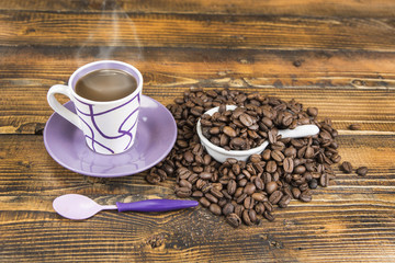 Cup od coffe with roasted bean on the wooden table.