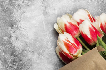 Bouquet of white pink tulips on a gray background. Top view, copy space