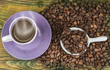 Cup od coffe with roasted bean on the wooden table.