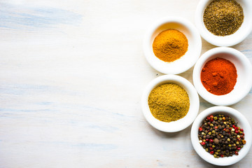 Different spices on white wooden table