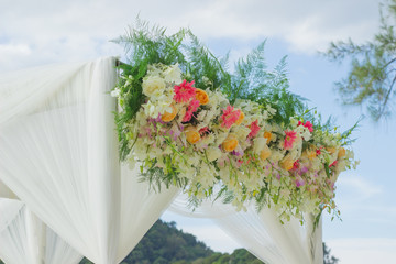 Wedding arch decorated and flowers on the beach