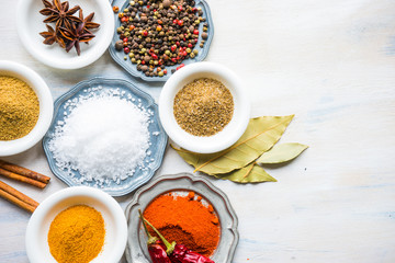 Different spices on white wooden table