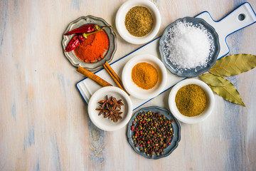Different spices on white wooden table