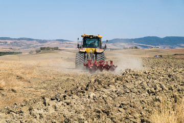 Peasant on the tractor while preparing the field for sowing