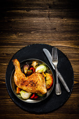 Barbecued chicken leg with baked potatoes and vegetables
