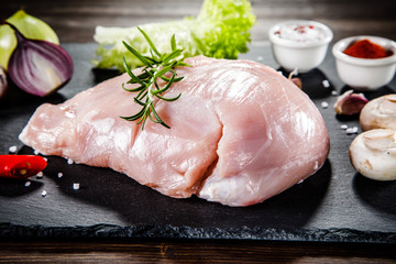 Raw chicken fillet on black stone