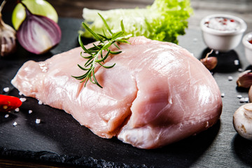 Raw chicken fillet on black stone