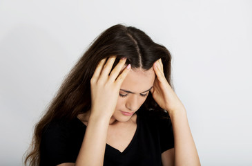 Portrait of stressed and depressed teen holding her head.