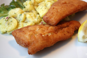 fish in breading with potato salad and lemon