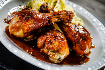 Grilled chicken legs with boiled potatoes on wooden background