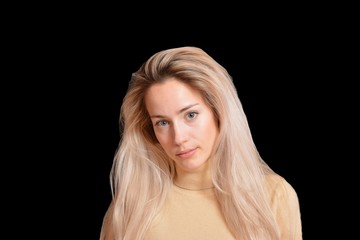 Portrait of blond girl with long beautiful hair on black background