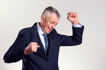 Portrait of a successful mid age businessman who is exulting with tight fists.