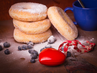 Blue cup of coffee with donuts, blueberries and red heart