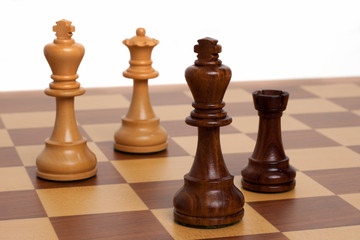 Braunes Schachbrett mit Figuren vor weißem Hintergrund