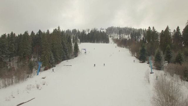 Aerial. Lonely skiers skiing down the ski track. 4K