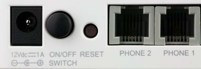 Closeup back of wifi router ports. There are two PSTN ports, power port, on/off button and reset.