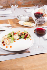 Starter: Mix salads, baked goat cheese, sea-buckthorn jam, caramelized pear with thyme, plum and roast nuts - served in a restaurant