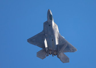 F-22 Raptor in a  high G maneuver, with condensation trail forming at the wing