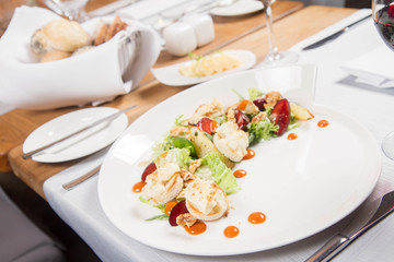 Starter: Mix salads, baked goat cheese, sea-buckthorn jam, caramelized pear with thyme, plum and roast nuts - served in a restaurant