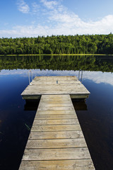 Empty footbridge over a tranquil lake in Mauricie national park, Canada