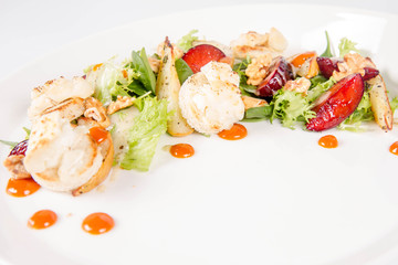 Starter: Mix salads, baked goat cheese, sea-buckthorn jam, caramelized pear with thyme, plum and roast nuts - on a white background