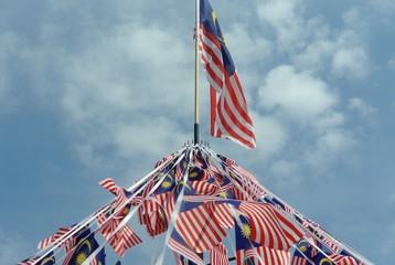 Selective focused small size Malaysia flag tie in large quantities in windy air. 
