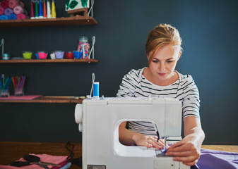 Female designer working on sewing machine