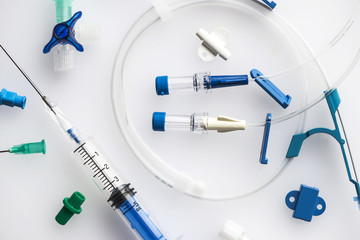 Image of neatly arranged syringe with needle and plastic tubes for central venous catheter...