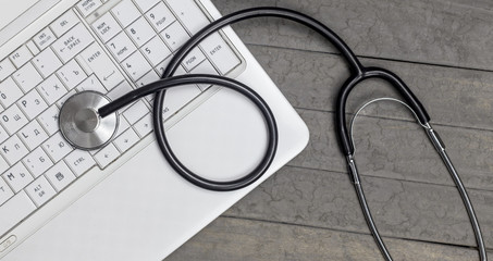 Fototapeta na wymiar top view of stethoscope with record information paper and Laptop