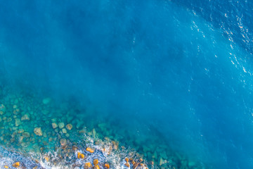 Fototapeta na wymiar Aerial view on turquoise waves that beat against stones in Montenegro