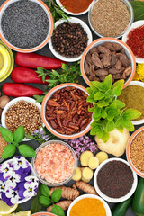 Herb spice and edible flower selection in bowls and loose forming an abstract background. Top view.