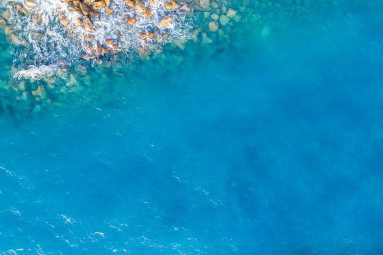 Aerial view on turquoise waves that beat against stones in Montenegro