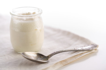 Yogurt in glass jar with spoon